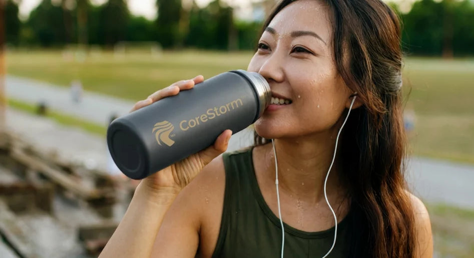 Women drinking Vegan Recovery Repair protein Powder from a CoreStorm water bottle