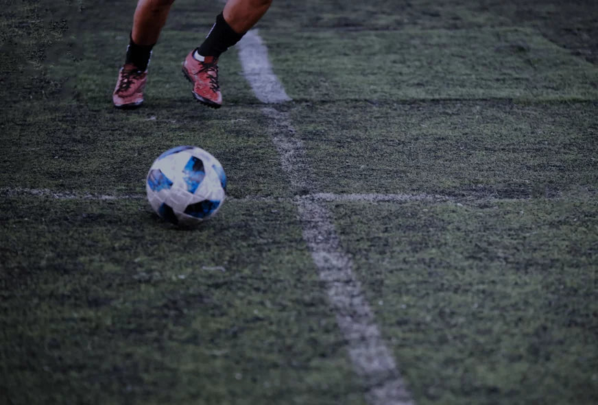 CoreStorm Football on a grass field with a player's feet in the background