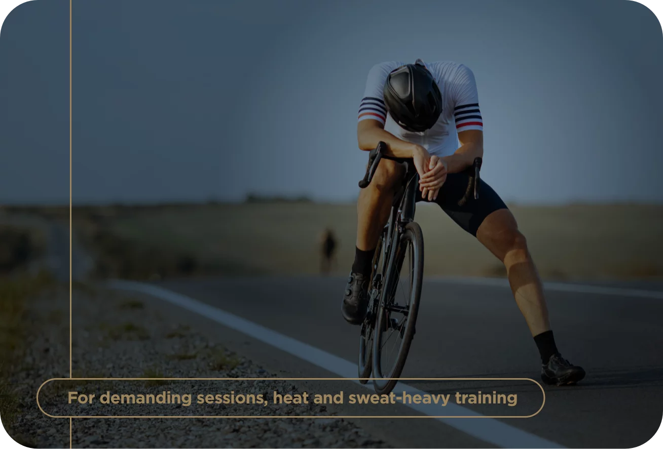 Cyclist in a racing outfit on a road with text about demanding training sessions.